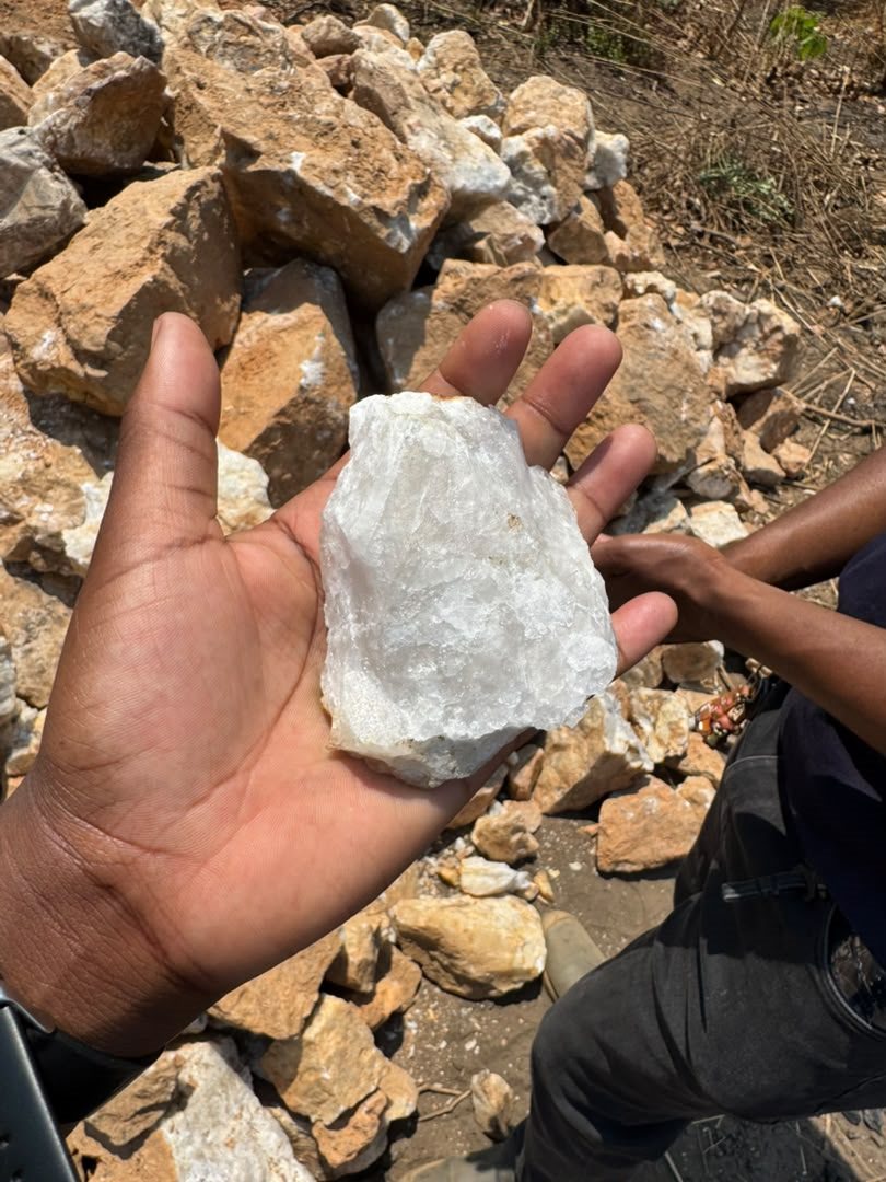 White mineral stone sample held in a hand